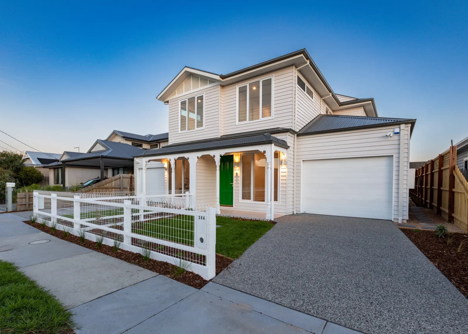 New weatherboard-style home build at dusk by Nicon Built